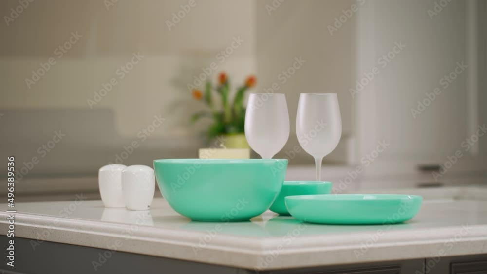 Dinner table setting. Green plates and wine glasses stand on the table. Set of utensils for dinner. Dinner table setting. Green plates and wine glasses stand on the table. Set of utensils for dinner.
