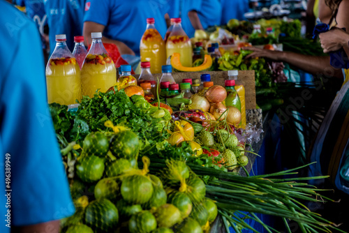Pessoas na feira do mercadão 2000 com verduras e frutas ao fundo, garrafa de tucupi, limão, cheiro verde em Santarém Pará  photo