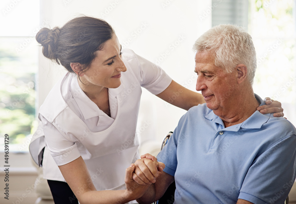 Obraz premium Home care with compassion. Shot of a caregiver helping a senior man in a wheelchair at home.