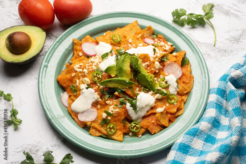 Red chilaquiles with cheese and avocado. Mexican food