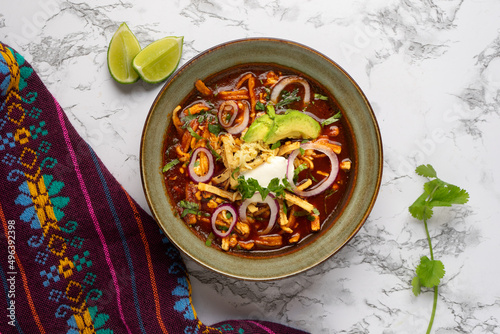 Tortilla soup with avocado and cheese. Mexican food photo