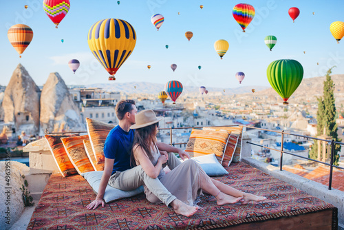 Happy young couple during sunrise watching hot air balloons in Cappadocia, Turkey photo