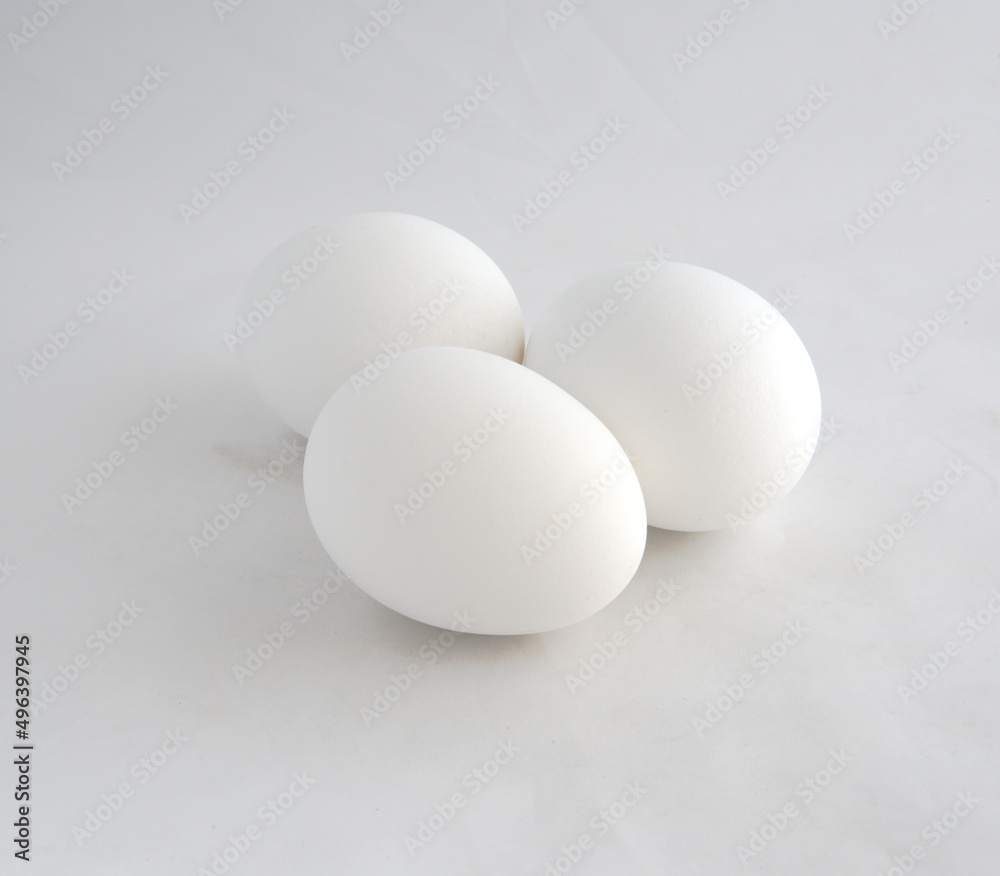 Three white chicken eggs ready to be decorated for a holiday. Three white chicken eggs ready to be decorated for a holiday.