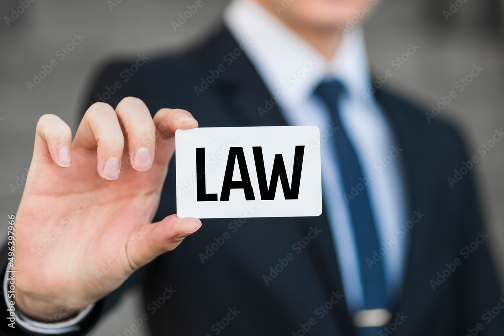 Man showing paper with LAW text Man showing paper with LAW text