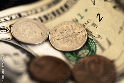 Nota de 1 Dólar dos Estados Unidos com moedas em fotografia macro. Conceitos de economia e finanças. Foco na moeda de dez centavos de dólar. photo