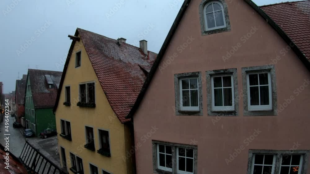 SLOW MOTION SHOT - Fairytale snowfall over the roofs in Rothenburg, Germany. Snow falls against the roof of German houses. SLOW MOTION SHOT - Fairytale snowfall over the roofs in Rothenburg, Germany. Snow falls against the roof of German houses.