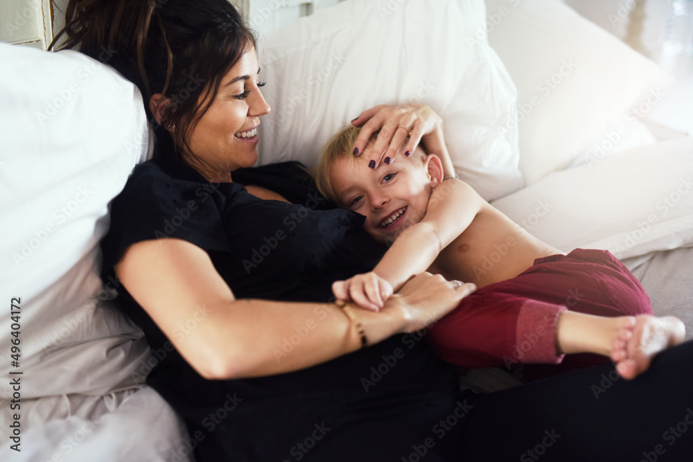 My precious little darling. Shot of a cheerful little boy and his mother hanging out on the bed at home while relaxing during the day. My precious little darling. Shot of a cheerful little boy and his mother hanging out on the bed at home while relaxing during the day.