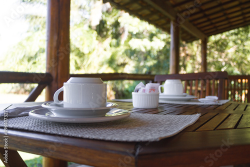 Mesa de Café da manhã com xícara de café ou de chá com um ambiente emadeirado e com verdes