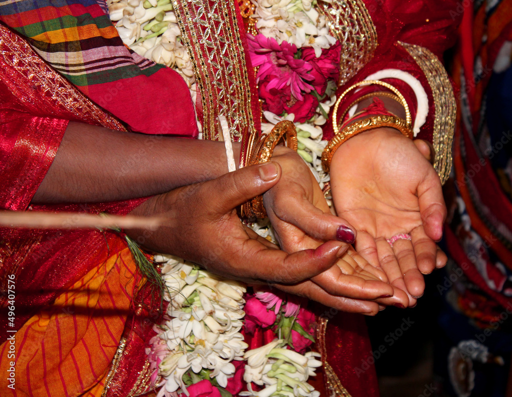 Traditional Bengali Hindu wedding ceremony, groom holding hand in bride hand. Selective focus