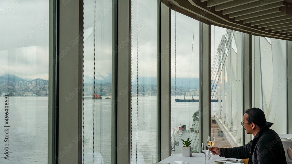 A man enjoying life with fine wine and dining facing panoramic ocean and mountain view A man enjoying life with fine wine and dining facing panoramic ocean and mountain view