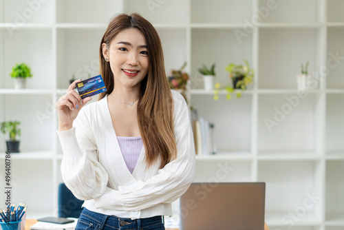 Asian woman holding credit card, name concept and online payment