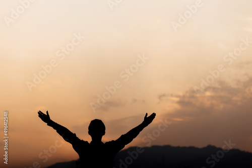 Obraz na plátne Silhouette of a man lift hands up and prayer at sunset