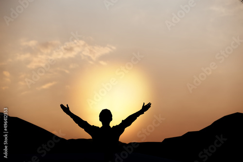 Silhouette of a man lift hands up and worship God at sunset. concept of religion.