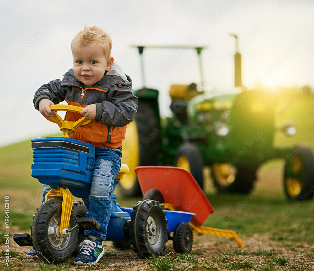 Nothing beats having a farm for playground. Portrait of an adorable little boy riding a toy truck on a farm. Nothing beats having a farm for playground. Portrait of an adorable little boy riding a toy truck on a farm.