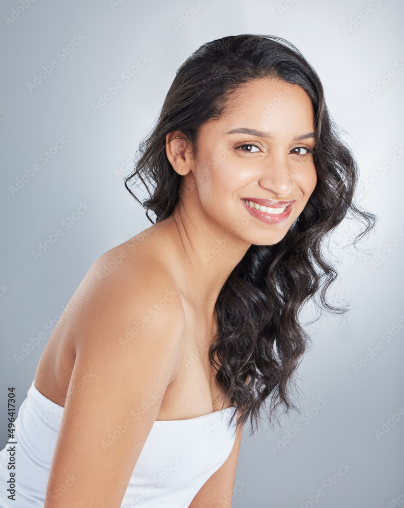 Obraz premium You can tell my mood simply by my hairstyle. Shot of an attractive young woman standing alone and posing with curly hair in the studio.