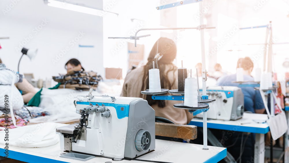 Concept Interior of garment factory. Closeup spool of multicolored threads for sewing machine Concept Interior of garment factory. Closeup spool of multicolored threads for sewing machine