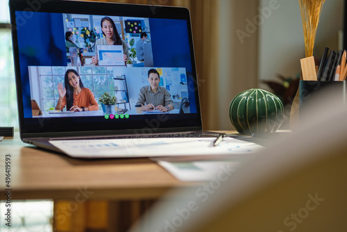 close up screen groupd of asian colleage video confernece business plan with laptop on table at home photo