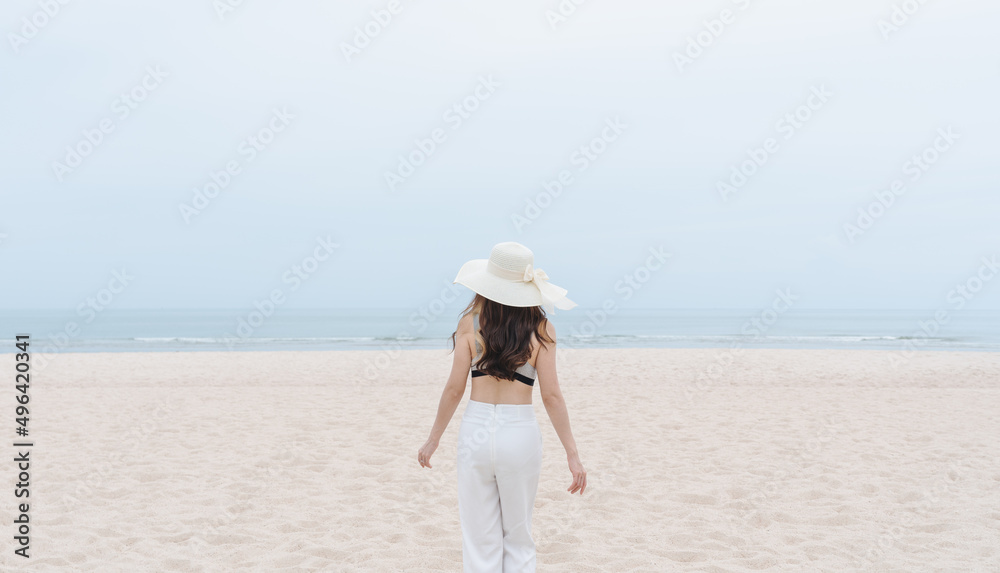 Vacation on the beach, Young woman walking on the beach in summer Vacation on the beach, Young woman walking on the beach in summer