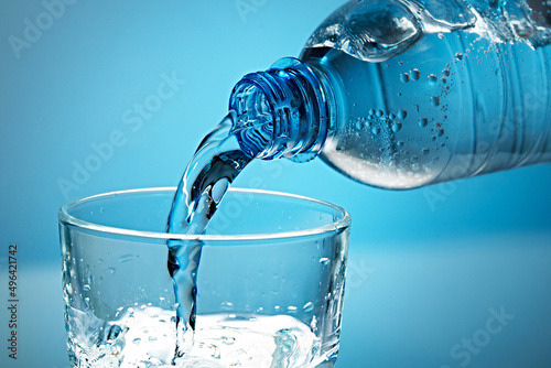 Mineral water is poured into a glass.