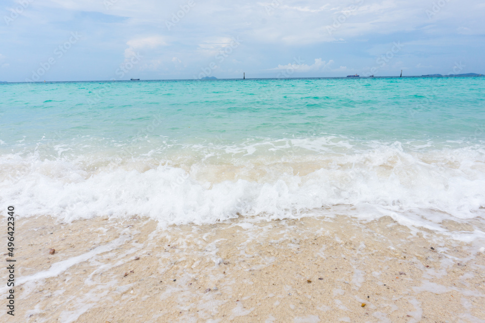 Wave of the blue sea on the sand beach on vacation.