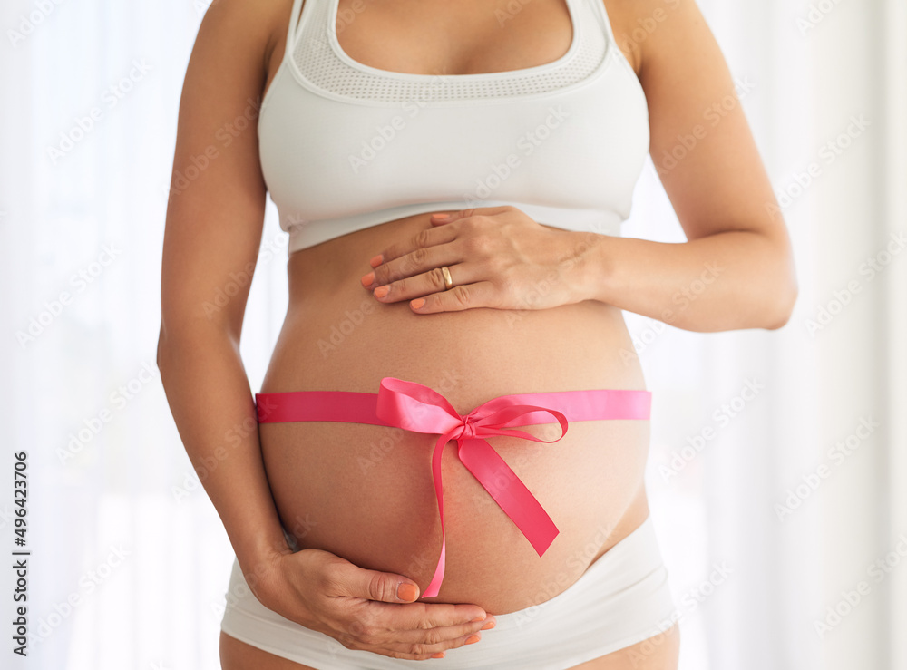 I was given the gift of pregnancy. Cropped shot of a woman with a pink ribbon tied around her pregnant belly. I was given the gift of pregnancy. Cropped shot of a woman with a pink ribbon tied around her pregnant belly.