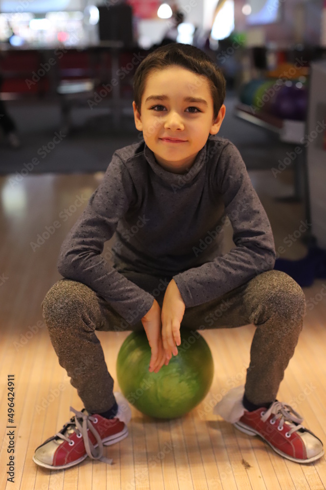 Fototapeta premium a boy is playing bowling.