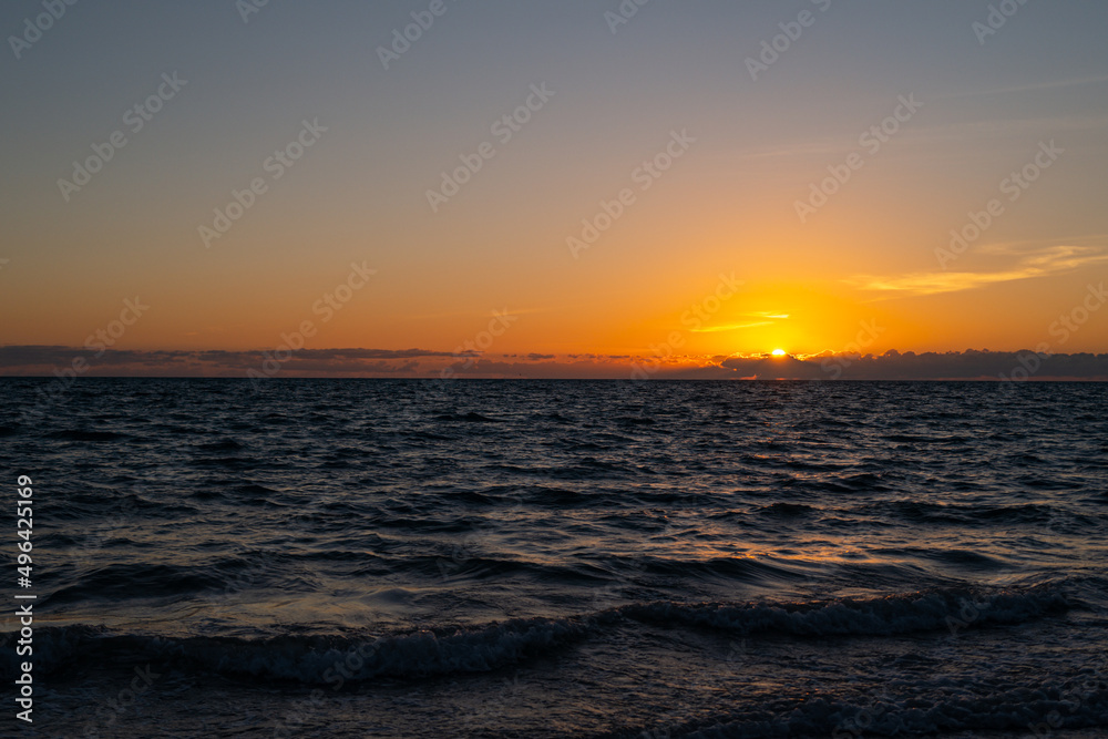 Sunset at sea landscape. Dramatic sunset sky with clouds. Dramatic sunset over the sea. Beautiful sunrise or sunset at sea.