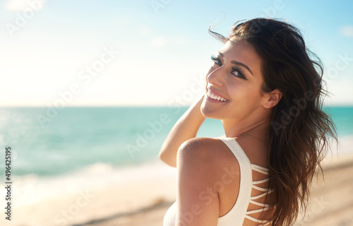 Summer sure does mean happiness. Cropped shot of a gorgeous young woman on the beach.