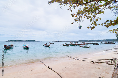 A view on a beach with longboats docked in the bay. © luengo_ua