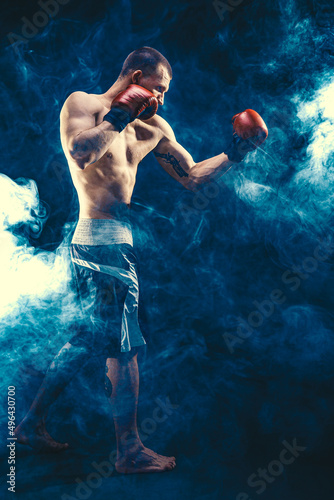 Full size of sportsman muscular boxer who fighting on black smoke background. Boxing sport concept