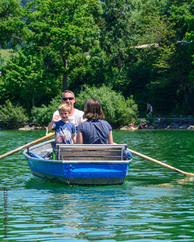 Familie mit kleinem Jungen macht eine Tour mit dem Ruderboot auf einem See