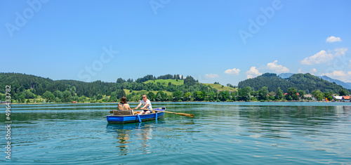 Familie mit dem Boot unterwegs auf dem idyllischen Alpsee in den Allgäuer Alpen nahe Immenstadt photo