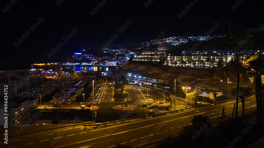 Beautiful night view of holiday resort town Puerto Rico de Gran Canaria, Canary Islands, Spain on the Atlantic coast with illuminated street and hotel.
