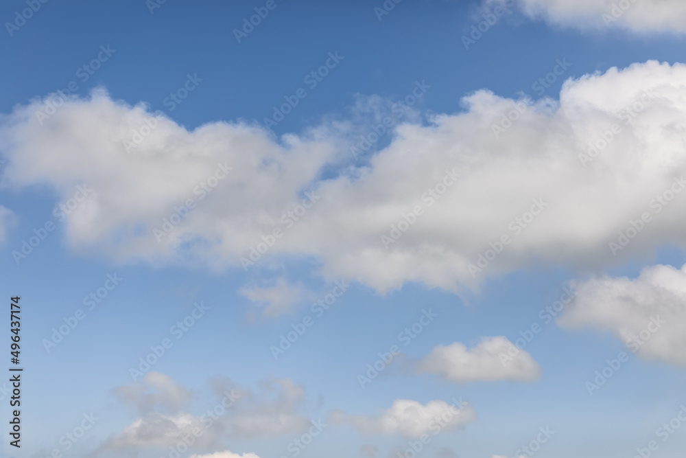 Serene and tousled cumulus clouds on a blue morning sky background