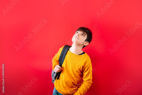 young friendly teenager with backpack on red background. © karrastock