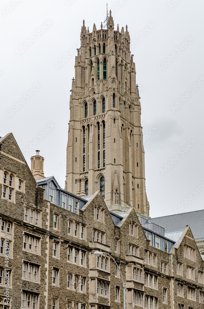 Fototapeta premium Riverside Church Tower during winter day with overcast, Building facades in the forefront, Harlem, New York City, vertical