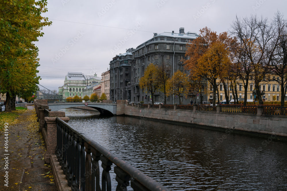 View of the Kryukov Canal embankment and an apartment building made of dark gray granite on an autumn day, St. Petersburg, Russia