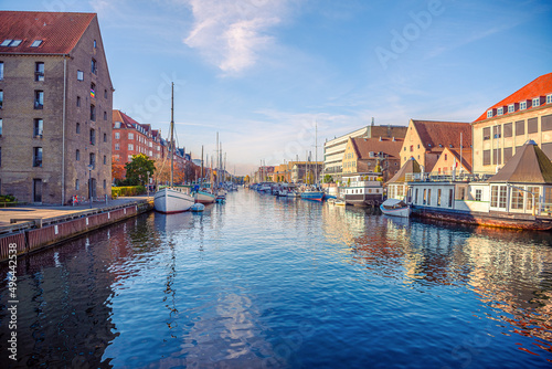 River canal with many boats and ships with small old houses in the  neighbourhood area Christianshavn in Copenhagen, Denmark © Chernobrovin