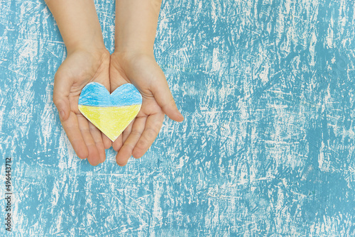 The national flag of ukraine with the coat of arms in female hands. Flat lay, copy space.