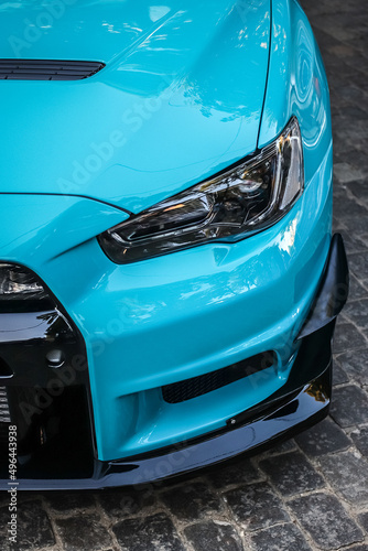 Close up headlight of a blue sports car. Modern car lighting equipment © solidmaks