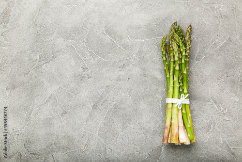 Bunch of green asparagus on concrete background. Top view  copy space