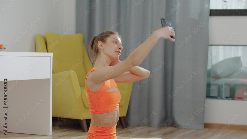 Pretty young woman in sports clothes takes selfies while her workout Pretty young woman in sports clothes takes selfies while her workout
