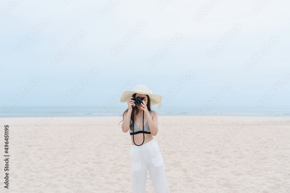 Vacation on the beach, Young woman in summer bikini taking photo 