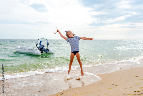 little girl jumping on the beach on the blue seashore in the summer holidays during the daytime 