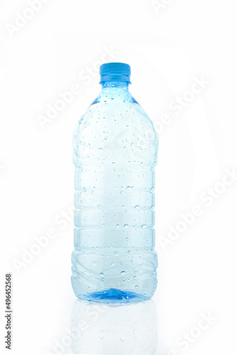 Empty wet transparent bottle isolated on white background. Blue plastic water packaging
