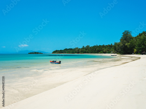 Fototapeta Naklejka Na Ścianę i Meble -  Scenic view of Koh Mak Island peaceful white sand beach with crystal clear turquoise water and local fishing boat against clear blue sky. Trat, Thailand.