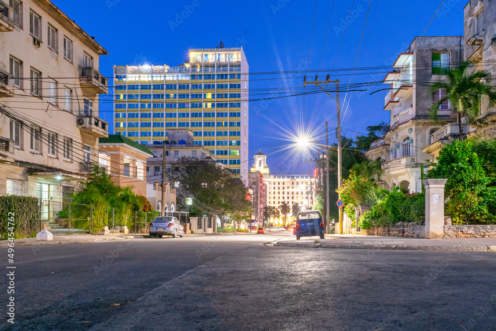 HAVANA, CUBA,  Long exposure of the M street in El Vedado downtown district. The Hotel Nacional de Cuba is seen in the distance behind another beautifully illuminated building.