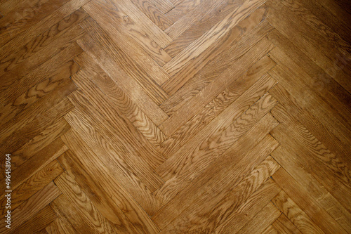 Classic wooden oak parquet in the form of a dark brown Christmas tree. Brown seamless parquet floor with a pattern of spruce from narrow boards