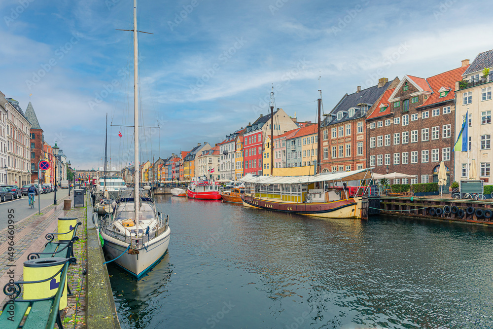 Many old boats, yachts and ships stand along the Nyhavn canal and colorful houses. Copenhagen, Denmark