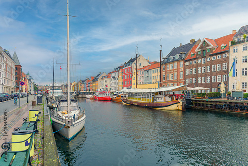 Many old boats, yachts and ships stand along the Nyhavn canal and colorful houses. Copenhagen, Denmark © Chernobrovin